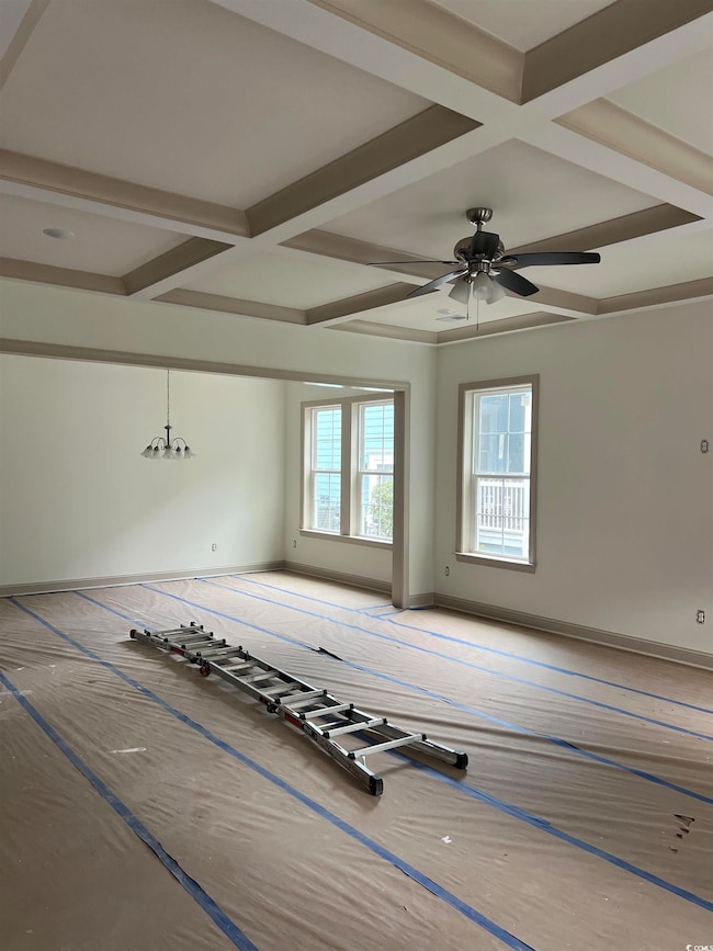 Spare room featuring coffered ceiling, beam ceiling, and ceiling fan