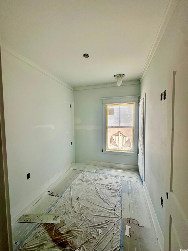Spare room featuring ornamental molding and baseboards