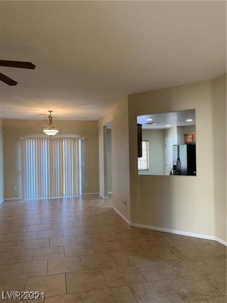 Unfurnished room with ceiling fan and baseboards