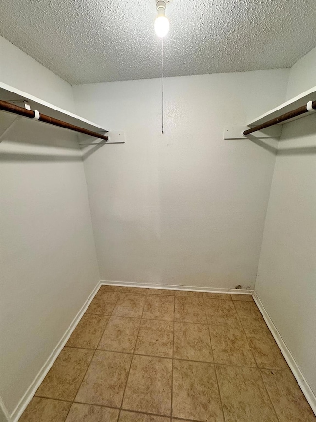 Spacious closet featuring tile floors