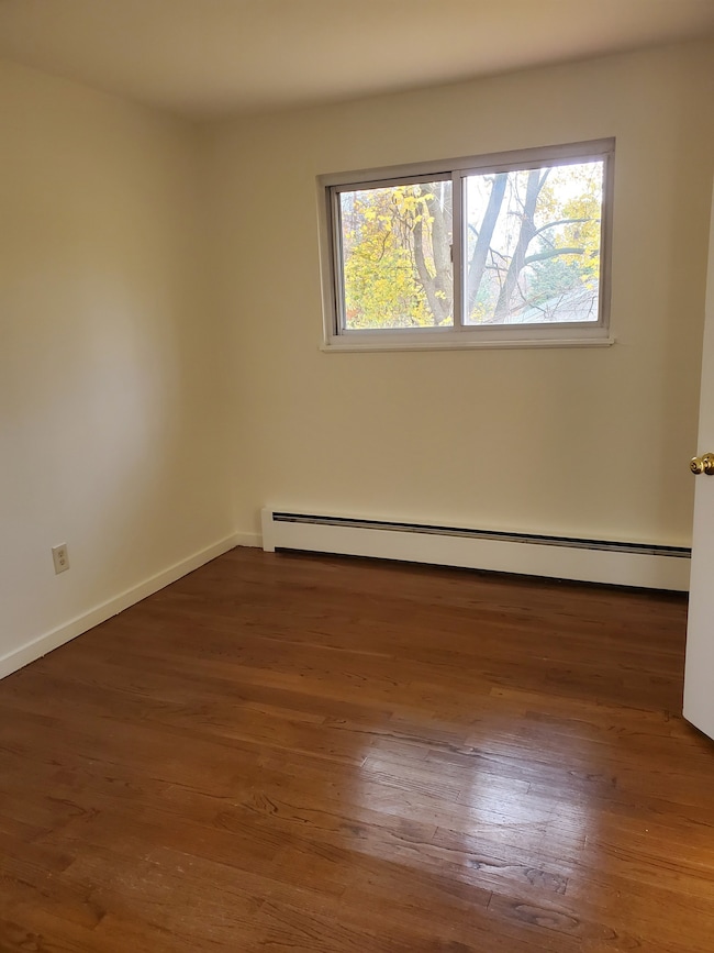 Bedroom has hardwood flooring and a closet.