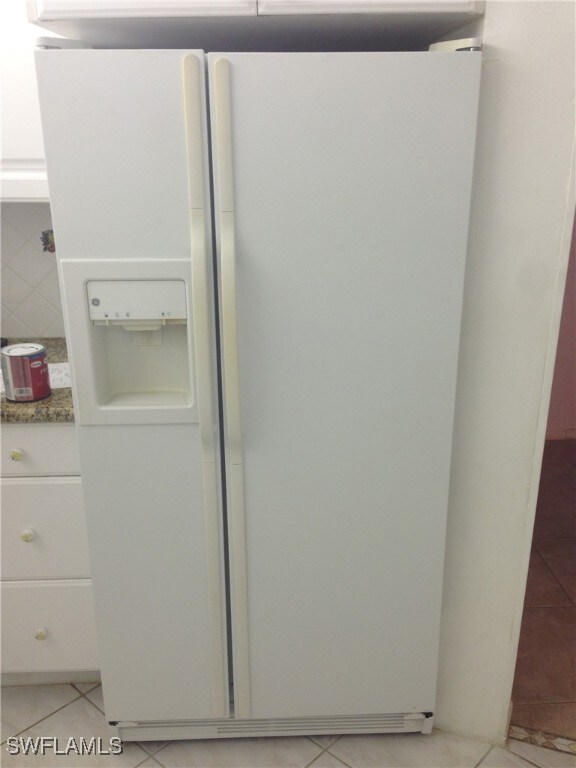 Kitchen view of white fridge with ice dispenser, w