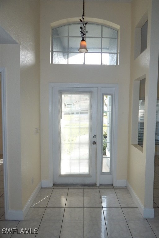 Foyer entrance featuring a towering ceiling, light