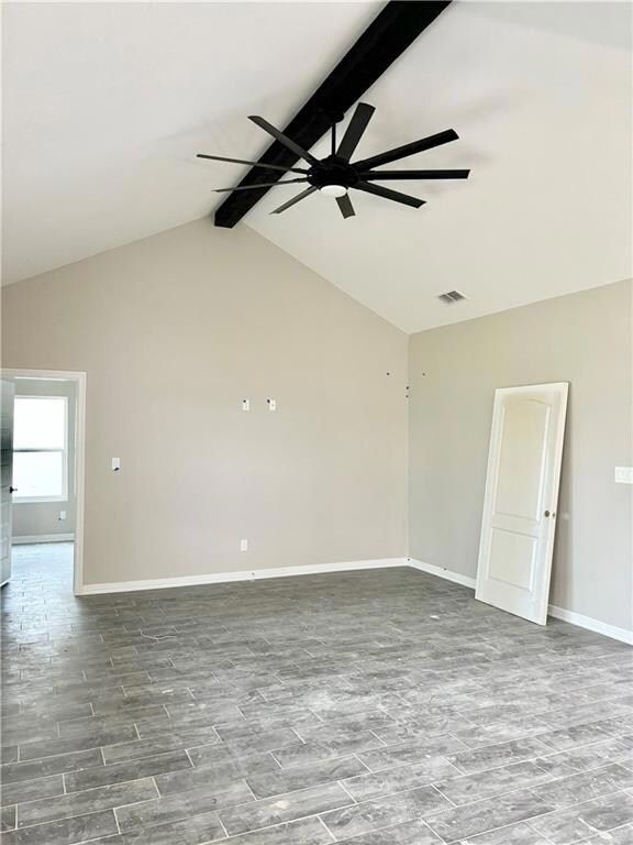 Empty room with high vaulted ceiling, ceiling fan, and beamed ceiling