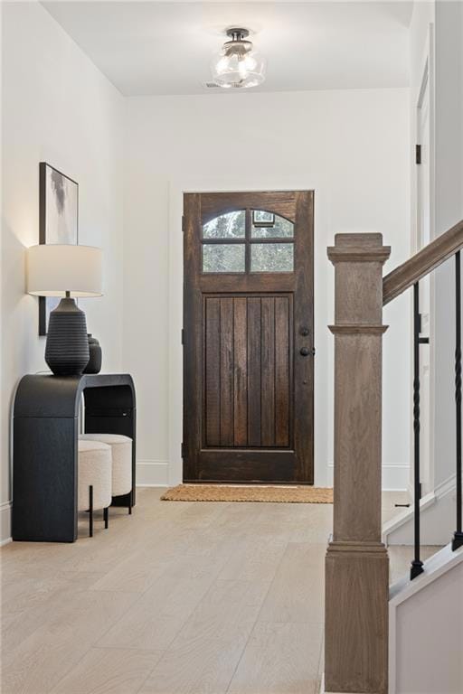 Entryway with wood finished floors and baseboards