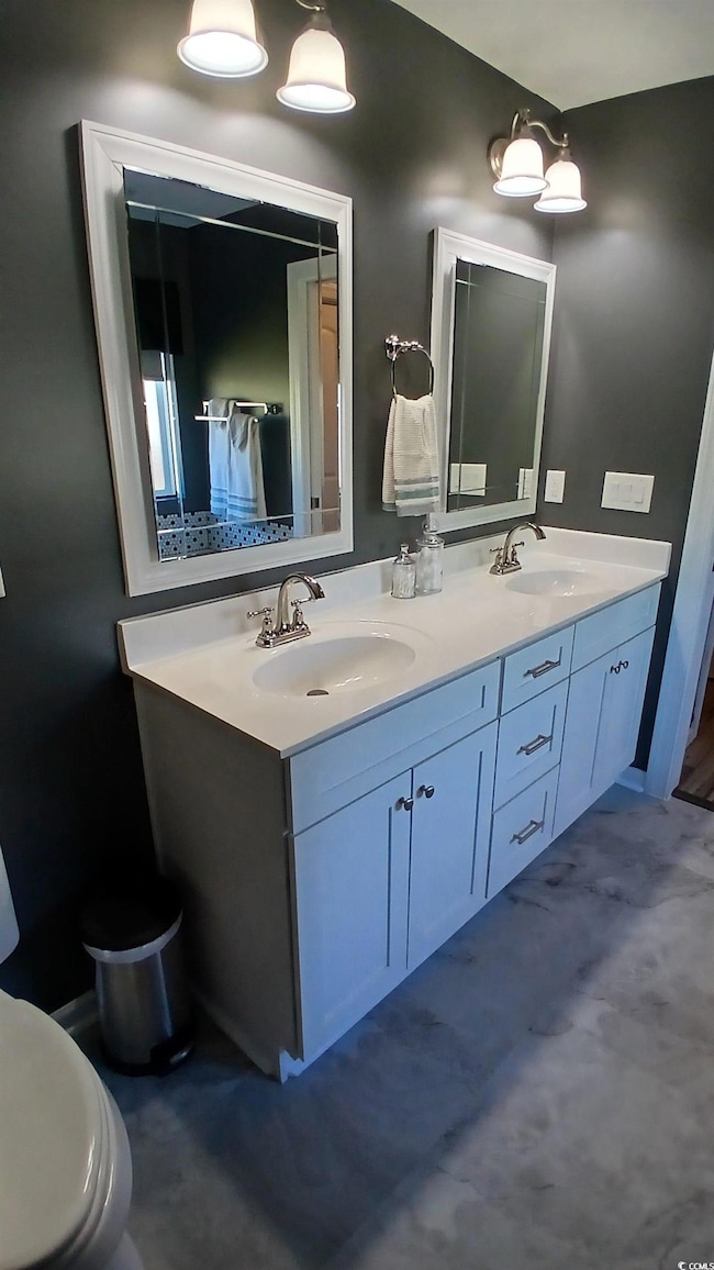 Full bathroom featuring double vanity and toilet
