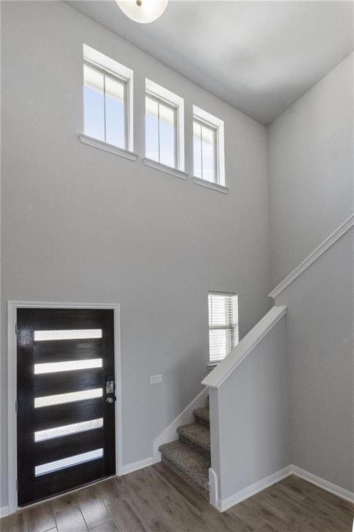 Foyer entrance with wood finished floors, stairs,