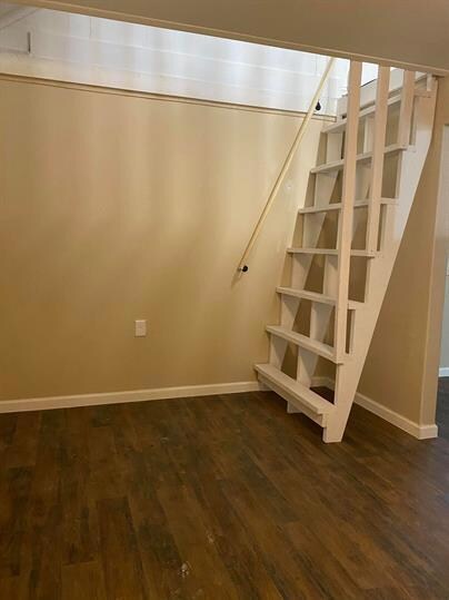 Below grade area featuring baseboards and dark wo