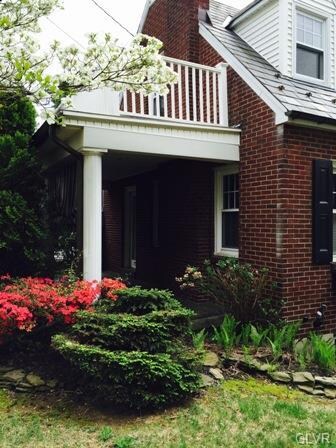 Side Porch Surrounded By Trees And Shrubbery