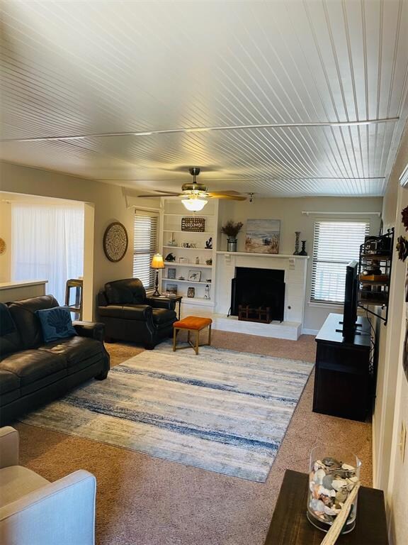 Living room with light colored carpet, ceiling fan