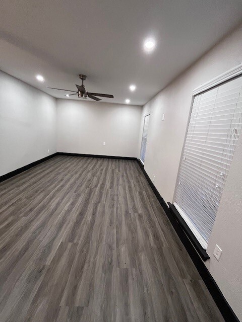 Spare room featuring dark wood-type flooring, ceiling fan, and recessed lighting