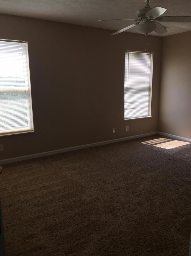 family rm with ceiling fan and lots of windows