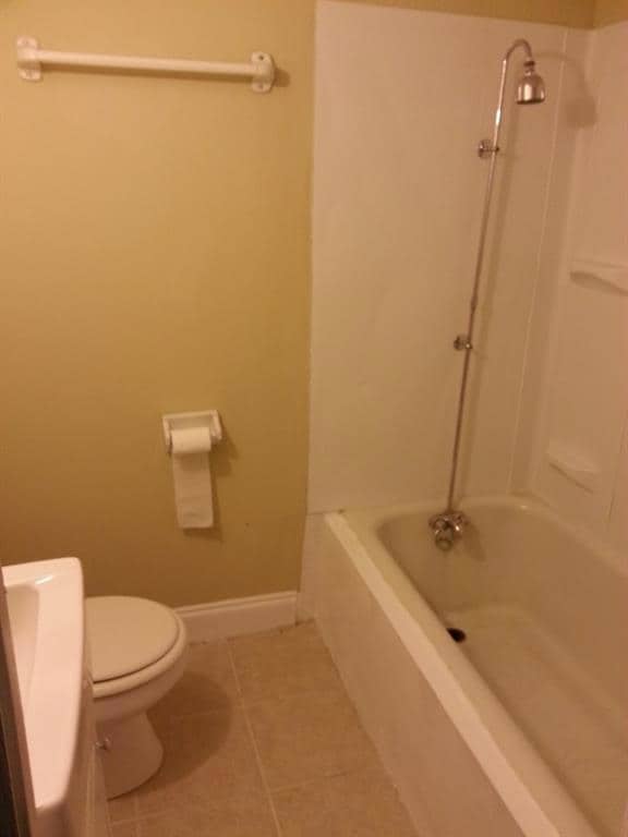 Full bath featuring tile patterned flooring, toilet, baseboards, shower / tub combination, and vanity
