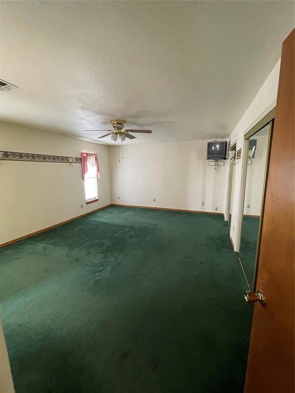 Primary bedroom with a textured ceiling, carpet fl