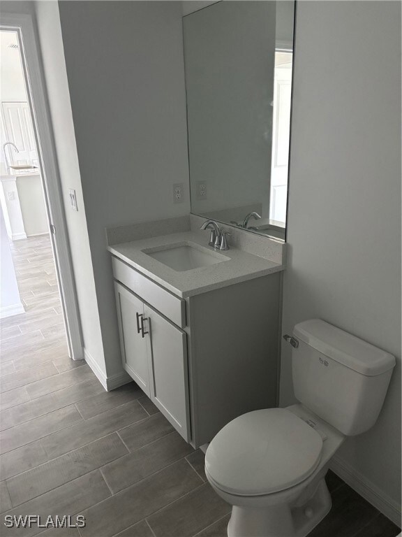 Half bathroom with wood tiled floors, vanity, toil