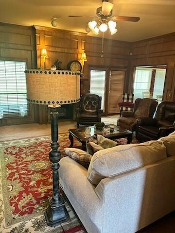 Carpeted living room featuring ceiling fan and woo