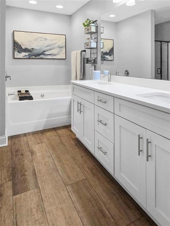 Bathroom featuring vanity, shower with separate ba