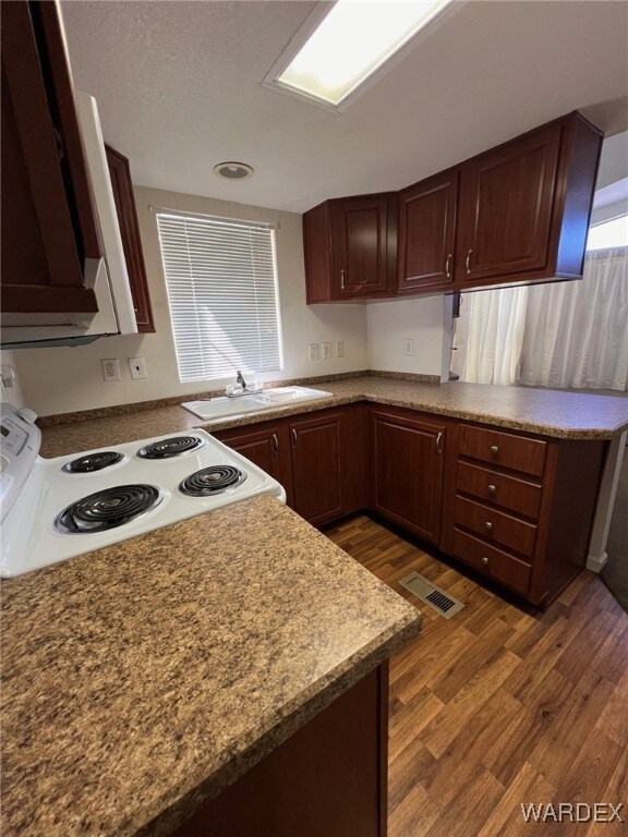 Kitchen featuring sink, electric range, and dark h