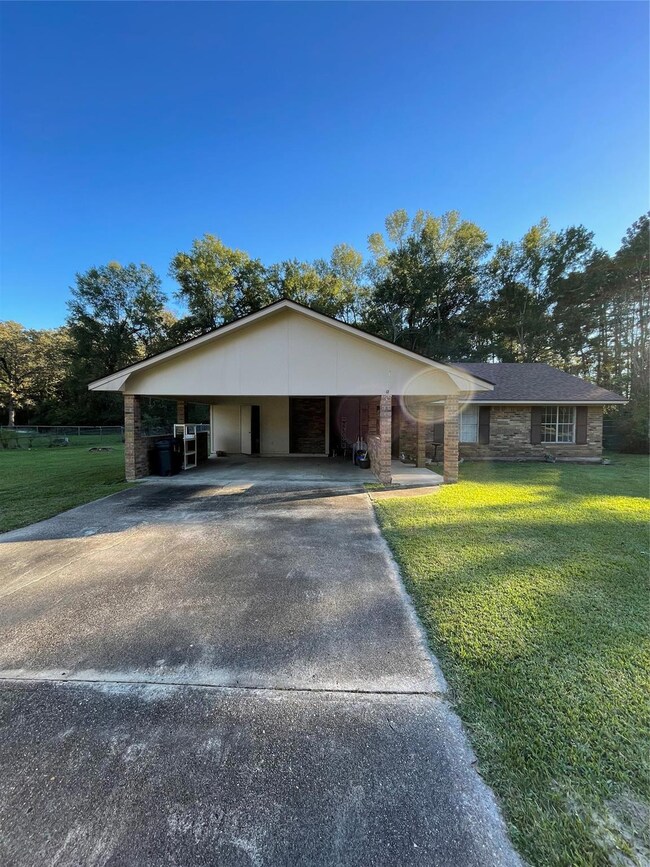 Single story home with a front yard and a carport