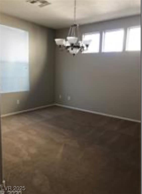 Empty room with a chandelier and baseboards