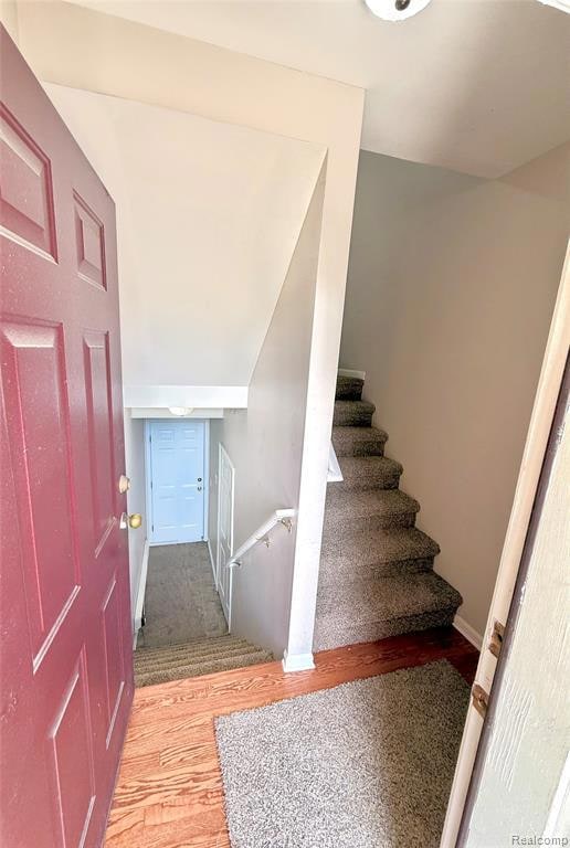 Stairs with wood finished floors and baseboards