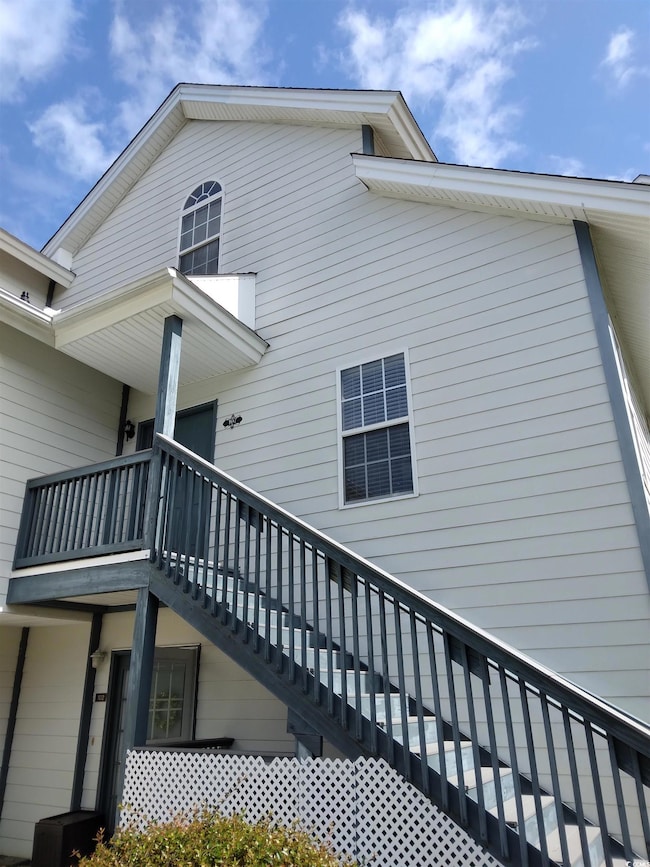 View of side of home with a balcony and stairway