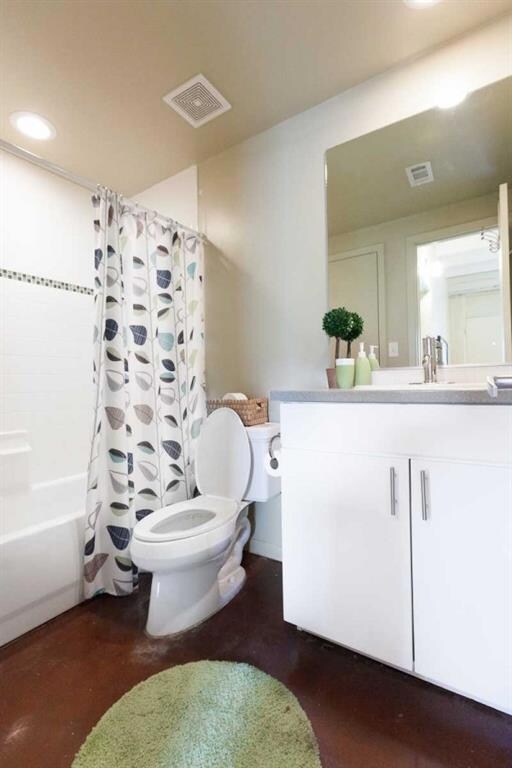 Full bath with visible vents, toilet, vanity, and