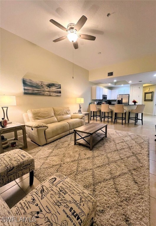 Living room with ceiling fan and a textured ceilin
