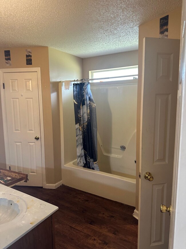 Bathroom featuring vanity, shower / bath combo wit
