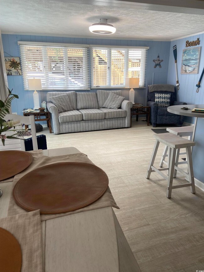 Living room featuring wood-type flooring and a tex