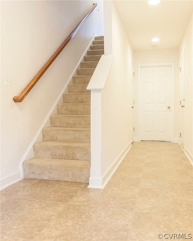 Entryway leading to garage, storage closet, and bedroom with attached bathroom.