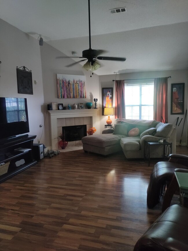 Living room featuring ceiling fan, lofted ceiling,