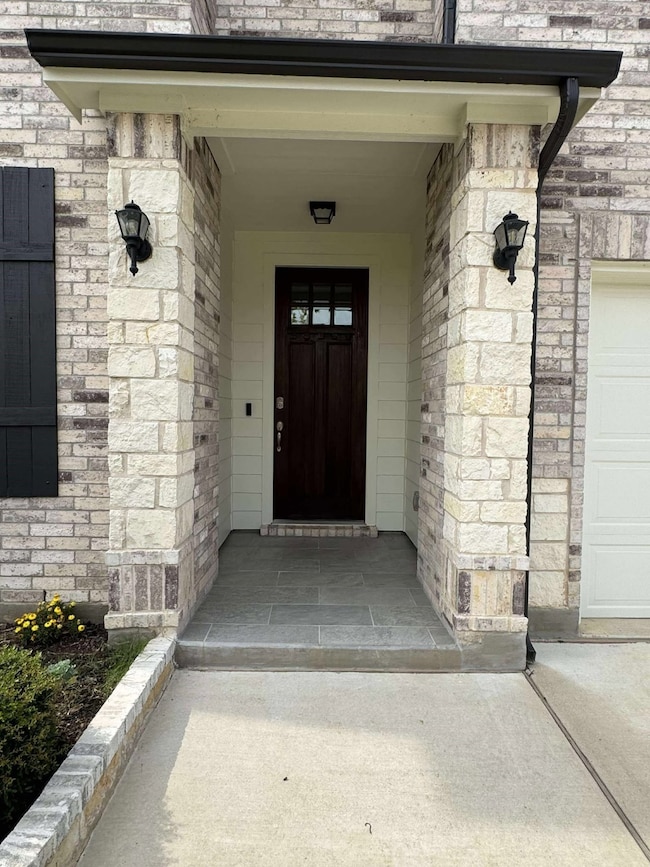 Property entrance with a garage and covered porch