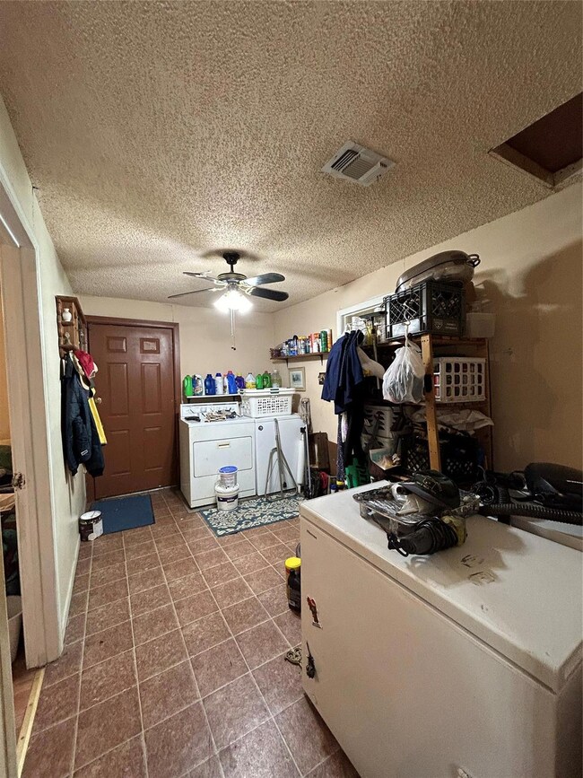 Washroom with ceiling fan, washer and clothes drye