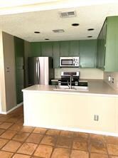 Kitchen featuring green cabinetry, appliances wit