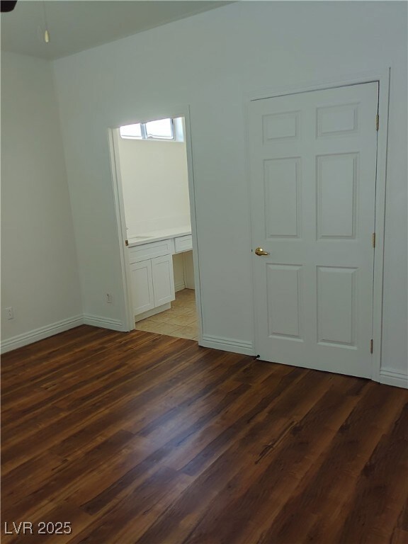 Spare room featuring dark wood finished floors and a desk
