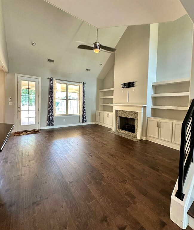 Unfurnished living room featuring ceiling fan, hig