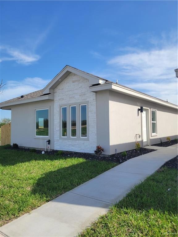 View of property exterior with a yard