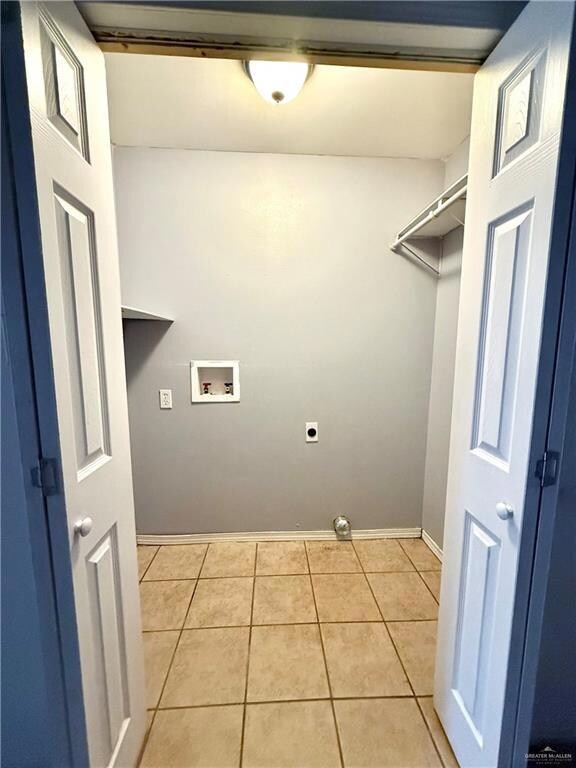 Laundry area featuring washer hookup, electric dryer hookup, and light tile patterned floors