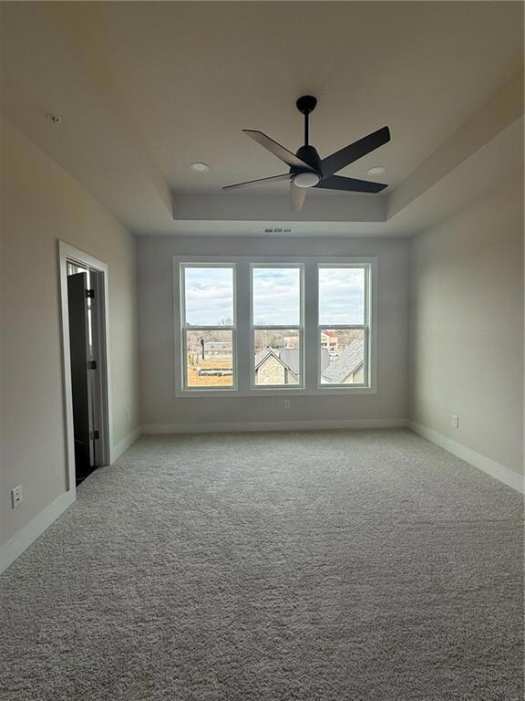 Master bedroom with a raised ceiling, carpet floor