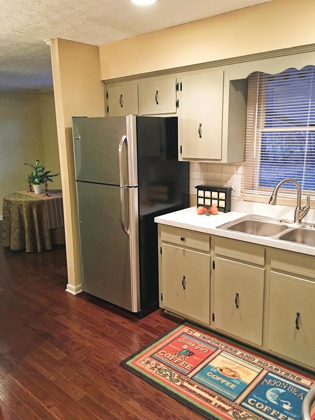 New Fridge (included with home) has wall panel to create a tidy look, painted cabinets, new custom counters. Large dining room beyond.