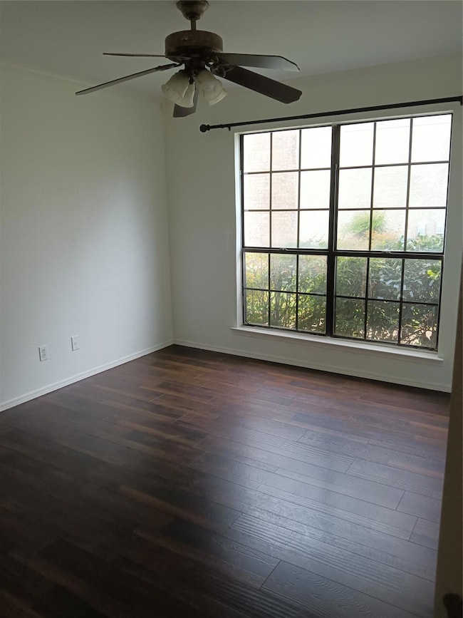 Spare room featuring baseboards, a ceiling fan, an