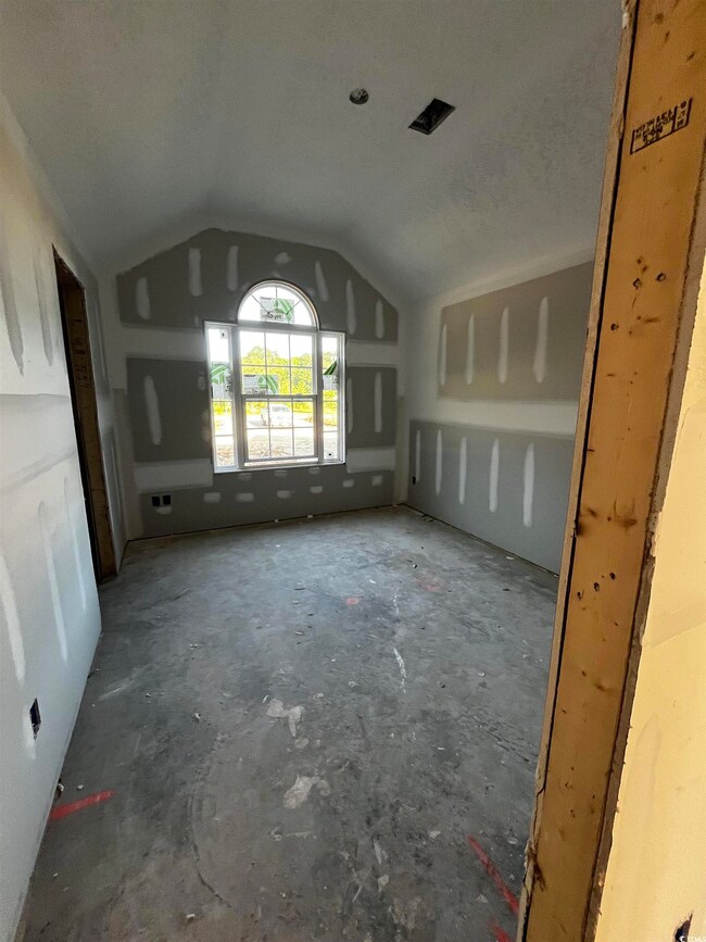 Unfurnished living room featuring vaulted ceiling