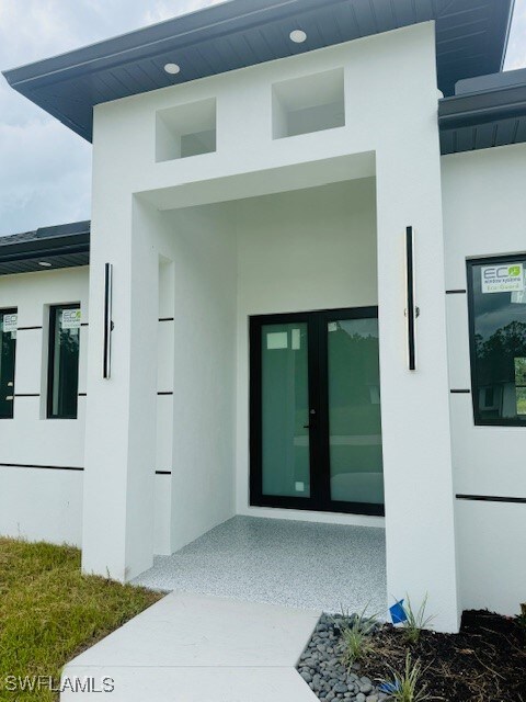 Entrance to property with stucco siding