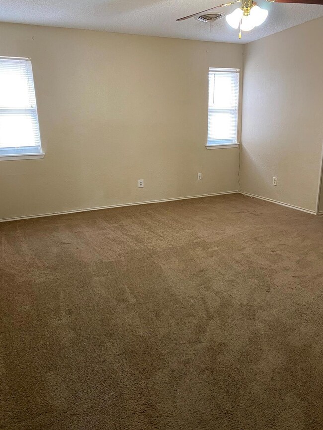 Spare room with a textured ceiling, carpet, and ce