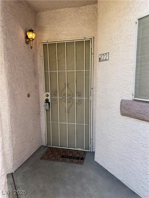 View of exterior entry featuring stucco siding