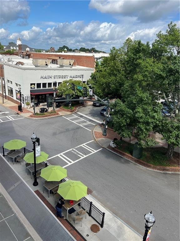 View of asphalt road with curbs, street lights, and sidewalks