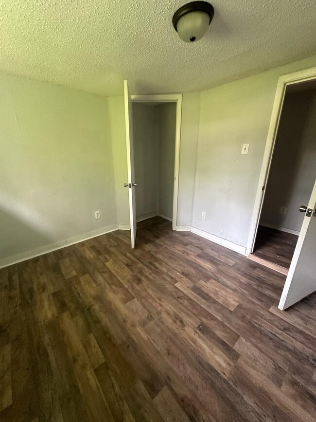 Unfurnished bedroom featuring dark wood-type floor