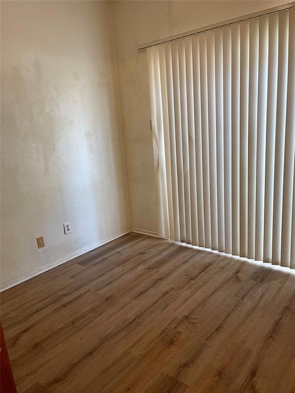 Spare room with baseboards and wood finished floors