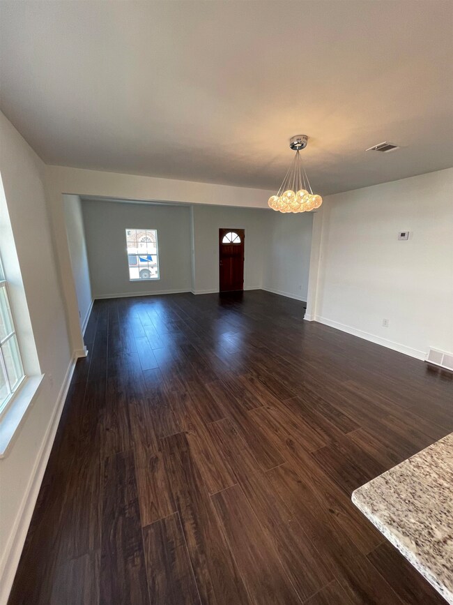 Unfurnished living room with a notable chandelier,